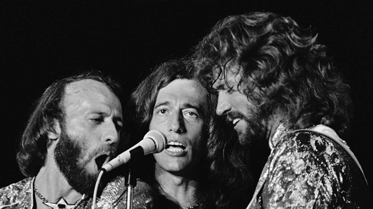 Grupės „Bee Gees“ nariai (iš kairės) Maurice'as, Robinas ir Barry Gibbai 1979 metais vykusiame koncerte