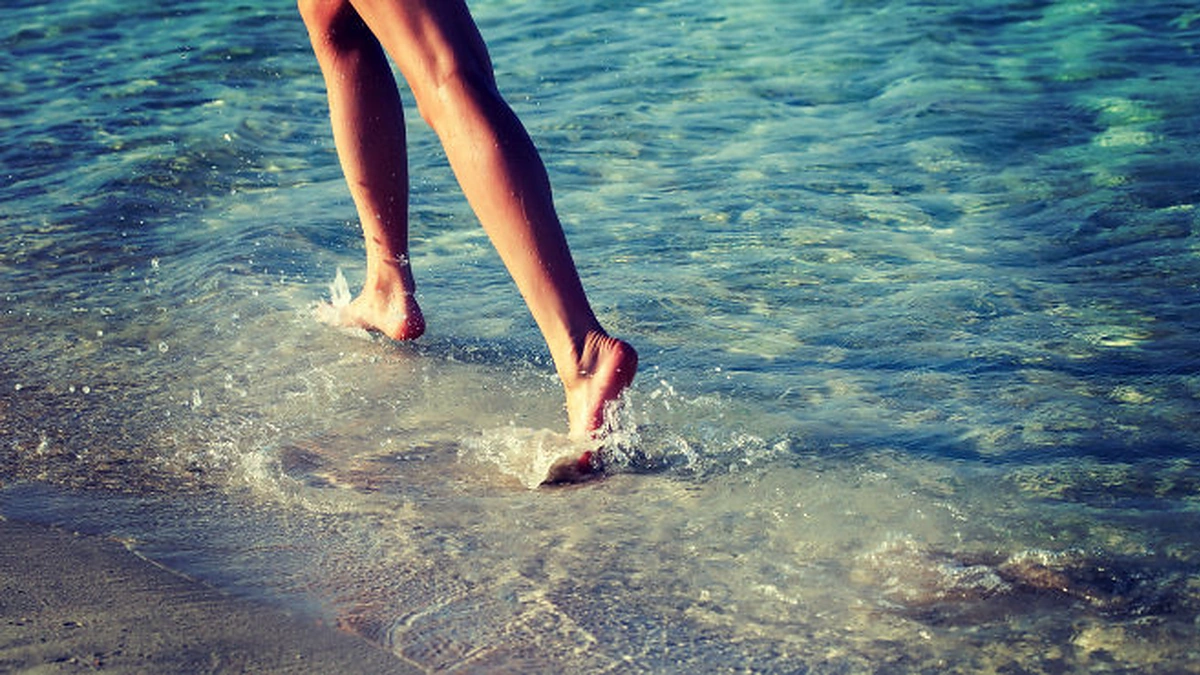 Moteris bėga jūros pakrante