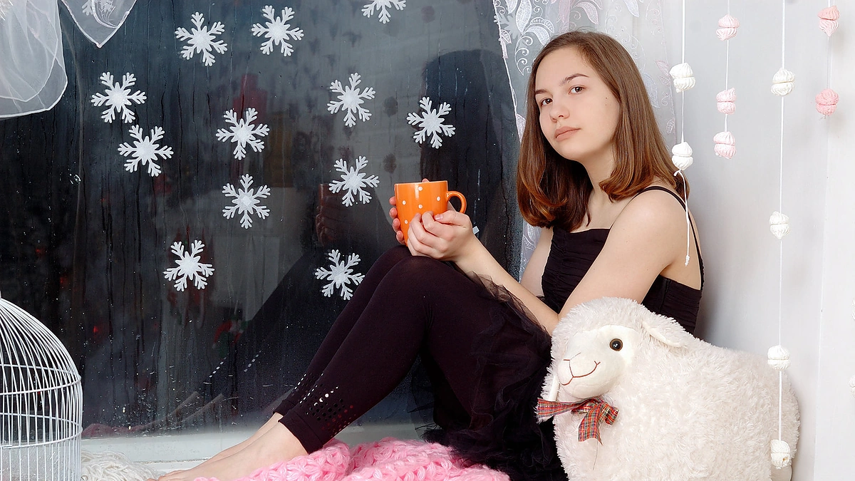 Mergina, sėdinti prie lango.