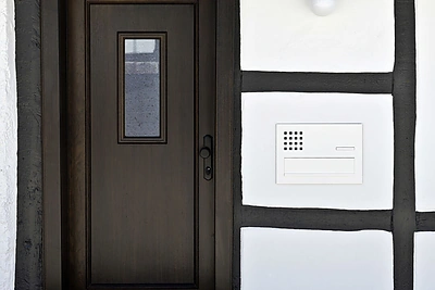 Telefonspynė namo eksterjere.