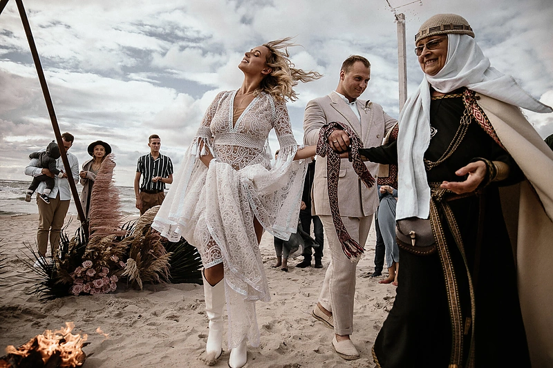 Jaunieji norėjo, kad šventėje vyrautų meilė ir vienybė, todėl net į tuoktuvių ceremoniją, kurią vedė vyriausioji Lietuvos krivė Inija Trinkūnienė, įtraukė visus svečius / „Portraits by Karolina“ nuotrauka