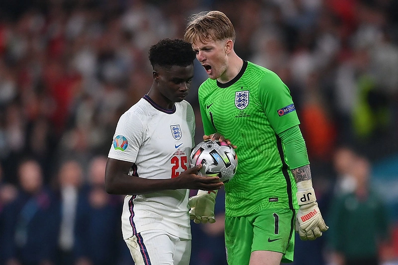 Anglijos rinktinės vartininkas Jordanas Pickfordas ir vidurio puolėjas Bukayo Saką per finalines rungtynes su Italija „Wembley“ stadione Londone