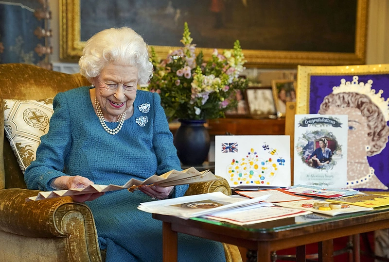 Elizabeth II apžiūri vaikų suvenyrus ir dovanėles, gautus įvairių jubiliejų proga / Scanpix nuotr.