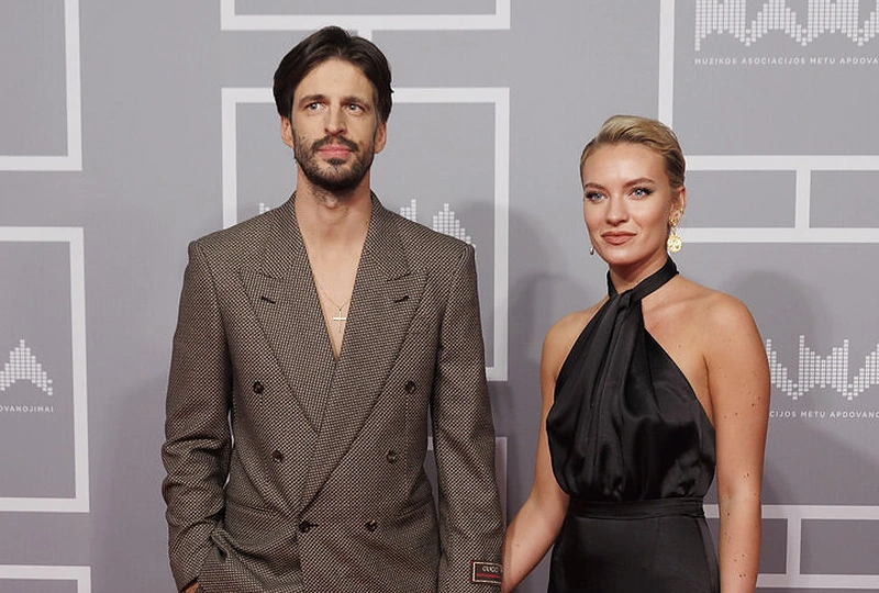 Dainininkas Justinas Jarutis su mylimąja chirurgijos rezidente Urte Andriuškevičiūte. Žavinga moteris šventinį vakarą vilkėjo „Undress“ suknele, Justinas – „Gucci“ kostiumu / Teodoro Biliūno / BNS nuotrauka