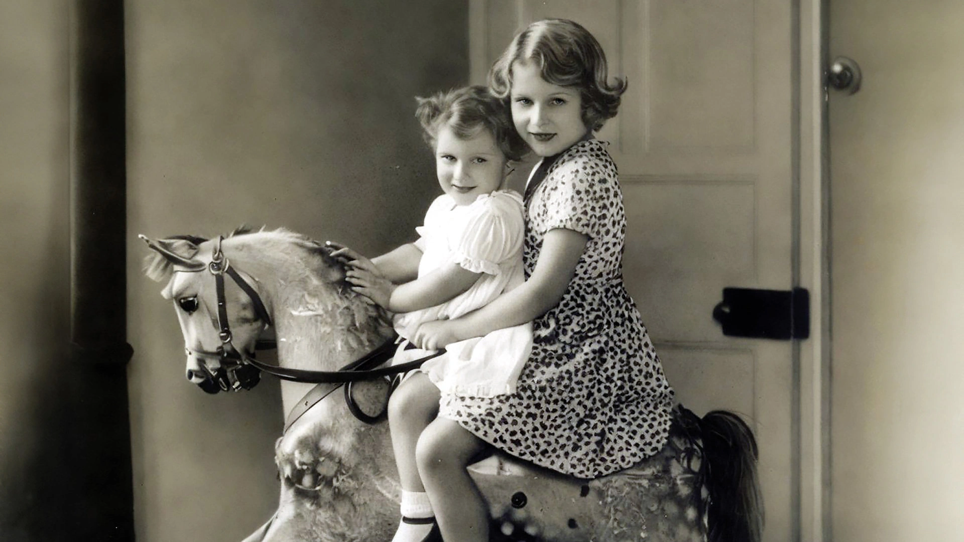 1932 metų nuotraukoje princesės Elizabeth ir Margaret supasi ant medinio arkliuko vardu Cezaris / Vida Press nuotrauka
